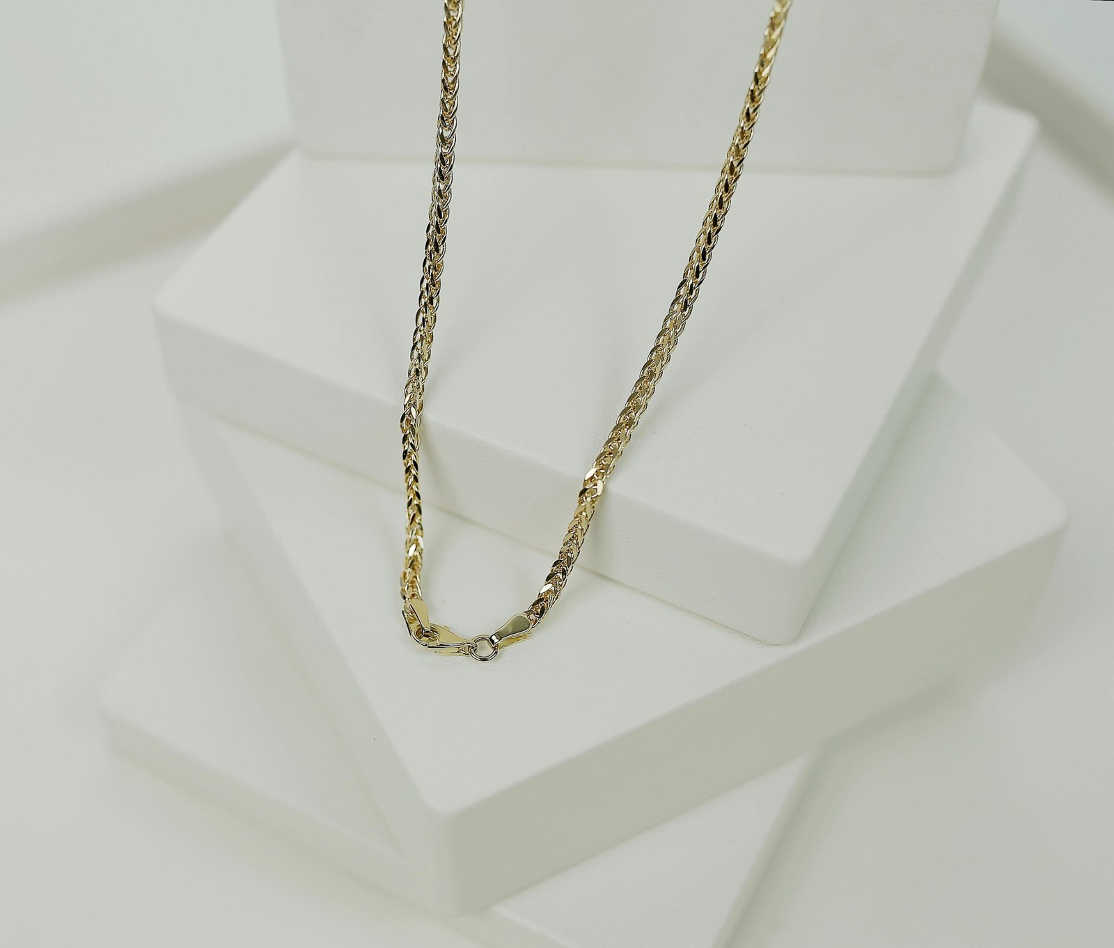 Sophisticated two-tone necklace displayed on sleek white platforms, ideal for upscale jewelry showcases.