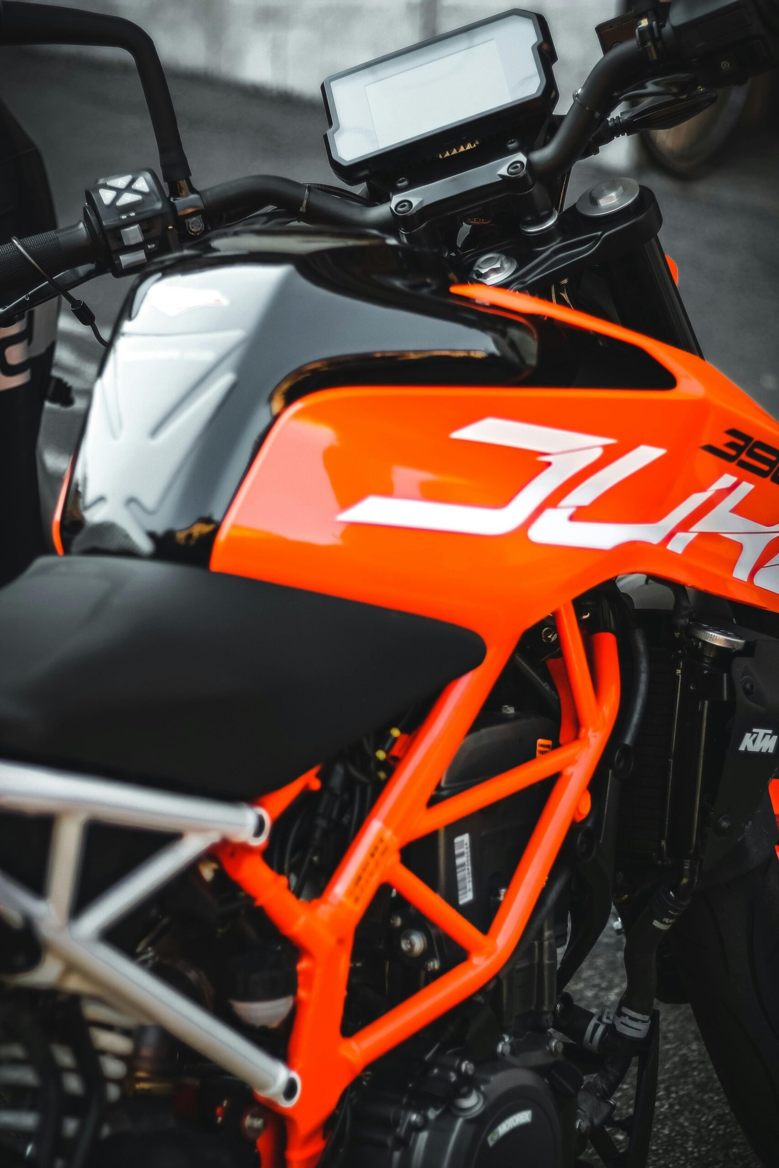 Close-up of a modern orange motorcycle showcasing its sleek design and vibrant color.